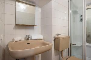 a white bathroom with a sink and a toilet at La vecia casa apartament in Denno +24 photos