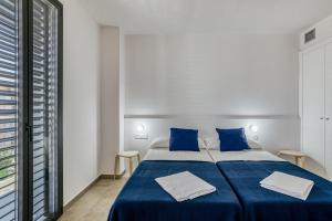a bedroom with a bed with blue sheets and a window at Murtra Apartment in Roses +18 photos