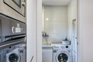 a laundry room with washing machines and a sink at Murtra Apartment in Roses