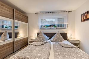 a bedroom with a bed and two windows at Ferienwohnung Am Weissgerber in Münsingen