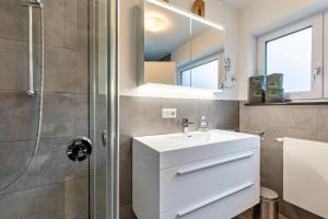 a bathroom with a white sink and a shower at Ferienwohnung Am Weissgerber in Münsingen +18 photos