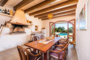 a kitchen and dining room with a wooden table and chairs at Finca Can Simonet in Santanyi