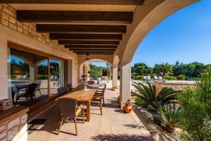 an outdoor patio with a wooden table and chairs at Finca Can Simonet in Santanyi