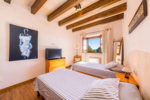 two beds in a room with a tv at Finca Can Simonet in Santanyi +20 photos