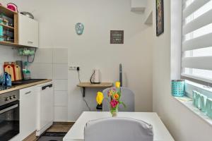 a white kitchen with a table and a vase of flowers at Ferienhaus Salzwedel in Salzwedel