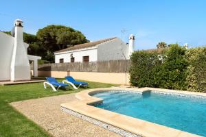 a swimming pool in a yard with two chairs and a house at Villa Perez Zara 2 in Campano