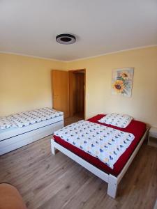 two beds sitting in a room with wooden floors at Ferienhaus Nosbers in Kleinlangenfeld