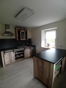 an empty kitchen with a black counter top and a window at Ferienhaus Nosbers in Kleinlangenfeld