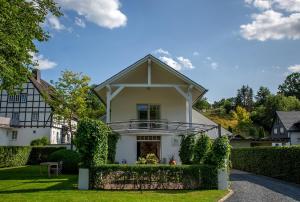 a white house with a fence in front of it at Ferienhaus Wennetraum mit Sauna in Eslohe