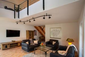 a living room with two couches and a tv at Ferienhaus Wennetraum mit Sauna in Eslohe
