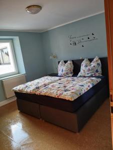 a bedroom with a bed with pillows on it at Ferienhaus Nosbers in Kleinlangenfeld +3 photos
