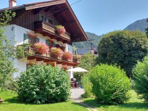 a building with potted plants on the balconies of it at Haus am Kurgarten - Seeberg in Bayrischzell