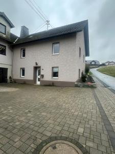 a large white house with a driveway at Ferienhaus Nosbers in Kleinlangenfeld