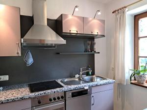 a kitchen with a sink and a stove at Haus am Kurgarten - Seeberg in Bayrischzell