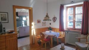 a living room with a table and a kitchen at Haus am Kurgarten - Seeberg in Bayrischzell