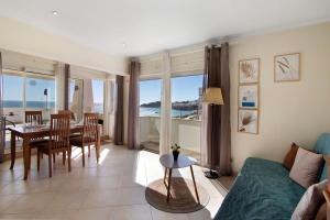 a living room with a couch and a table and chairs at Casa Vista Mar in Albufeira +15 photos