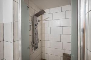 a bathroom with a shower with white tiles at Ferienwohnung Knopf in Hardegsen +12 photos