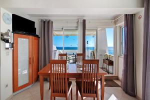 a dining room with a table and chairs with a view of the ocean at Casa Vista Mar in Albufeira