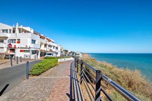 a road next to the ocean next to a building at Casa Vista Mar in Albufeira