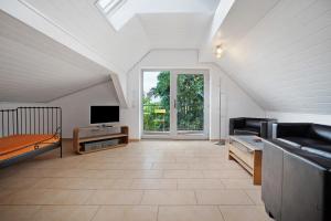 a room with a couch and a tv and a window at Storchensommer in Blankensee