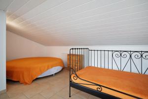 a bedroom with a bed with an orange blanket at Storchensommer in Blankensee