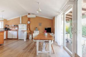 a kitchen and dining room with a table and chairs at Petit Havre Cosy Vue Pyrénénées in Estibeaux