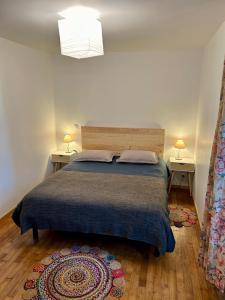 a bedroom with a bed with two tables and two lamps at Gite Charmant Forme et Bien-etre in Masseret +36 photos