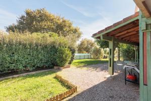 a backyard with a wooden roof and a lawn at Petit Havre Cosy Vue Pyrénénées in Estibeaux