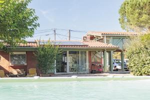 a house with a swimming pool in front of it at Petit Havre Cosy Vue Pyrénénées in Estibeaux