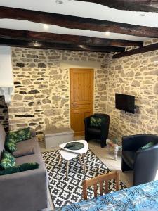 a living room with a stone wall at Gite Charmant Forme et Bien-etre in Masseret