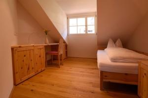 a bedroom with a bed and a desk and a window at Rosengartnerhof Apt Maultasch in Terlano