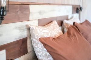 a bed with two pillows and a wooden wall at Las Hermanas B in Guía de Isora +21 photos