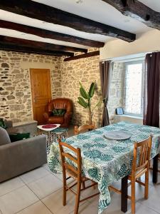a living room with a table and chairs at Gite Charmant Forme et Bien-etre in Masseret
