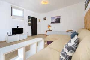 a living room with a couch and a tv at Famara Beach Apt in Famara