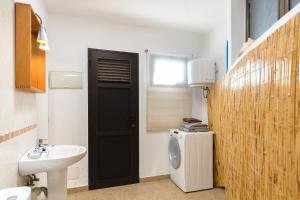 a bathroom with a sink and a washing machine at Famara Beach Apt in Famara +18 photos