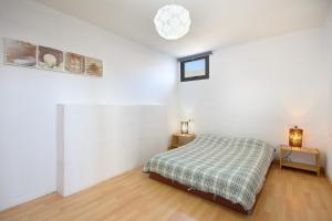 a white bedroom with a bed and two tables at Famara Beach Apt in Famara