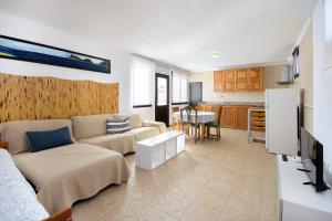 a living room with a couch and a kitchen at Famara Beach Apt in Famara