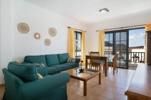 a living room with a blue couch and a table at Apartamento Fondeo in Tinajo