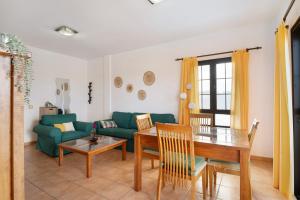 a living room with a green couch and a table at Apartamento Fondeo in Tinajo +13 photos