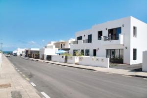 a street with white buildings on the side of a road at Apartamento Fondeo in Tinajo