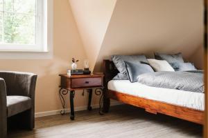 a bedroom with a bed and a table and a chair at Landhaus Elbenberg in Naumburg