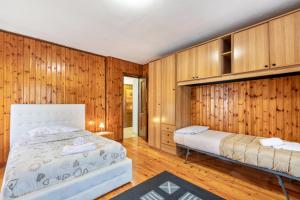 a bedroom with two beds and wooden walls at Alloggio Chez Favre in Blavy