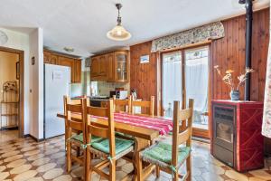 a dining room with a table and chairs and a kitchen at Alloggio Chez Favre in Blavy