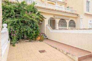 a building with a balcony and a garden with flowers at Bungalow 145 in Santa Pola