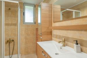 a bathroom with a sink and a shower at Angelina’s Stone Village House in Valíra +14 photos