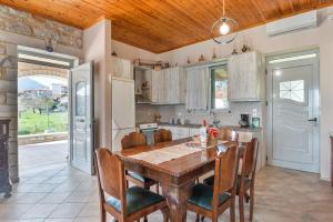 a kitchen with a wooden table and chairs at Angelina’s Stone Village House in Valíra