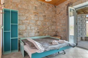 a bedroom with a bed and a stone wall at Angelina’s Stone Village House in Valíra