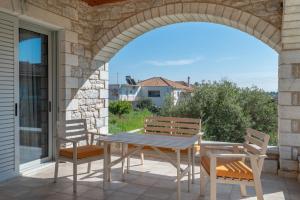 a table and chairs on a patio with an archway at Angelina’s Stone Village House in Valíra
