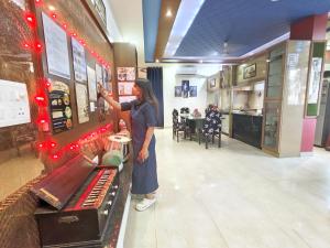 a woman standing next to a counter in a store at The Hideout Agra Garden Homestay - Near Taj Mahal in Agra