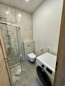 a bathroom with a toilet and a glass shower at Raudondvaris holiday home in Raudondvaris +13 photos
